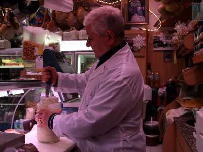 Quando entriamo scorgiamo il canuto titolare, munito di un camice bianco e intento a preparare un barattolo di ricotta forte